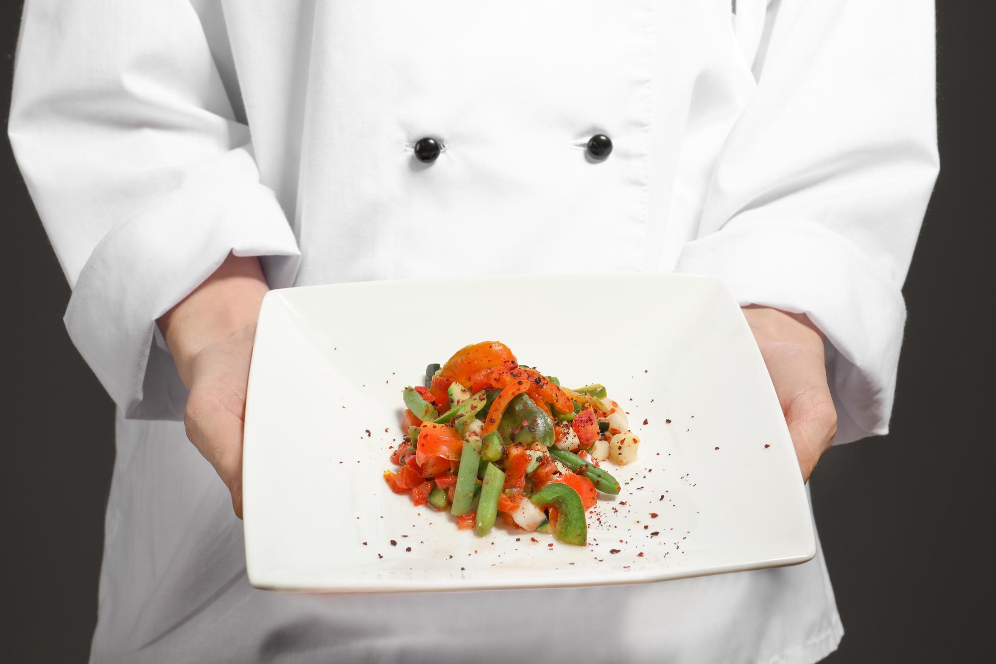 Chef al banco con piatto raffinato